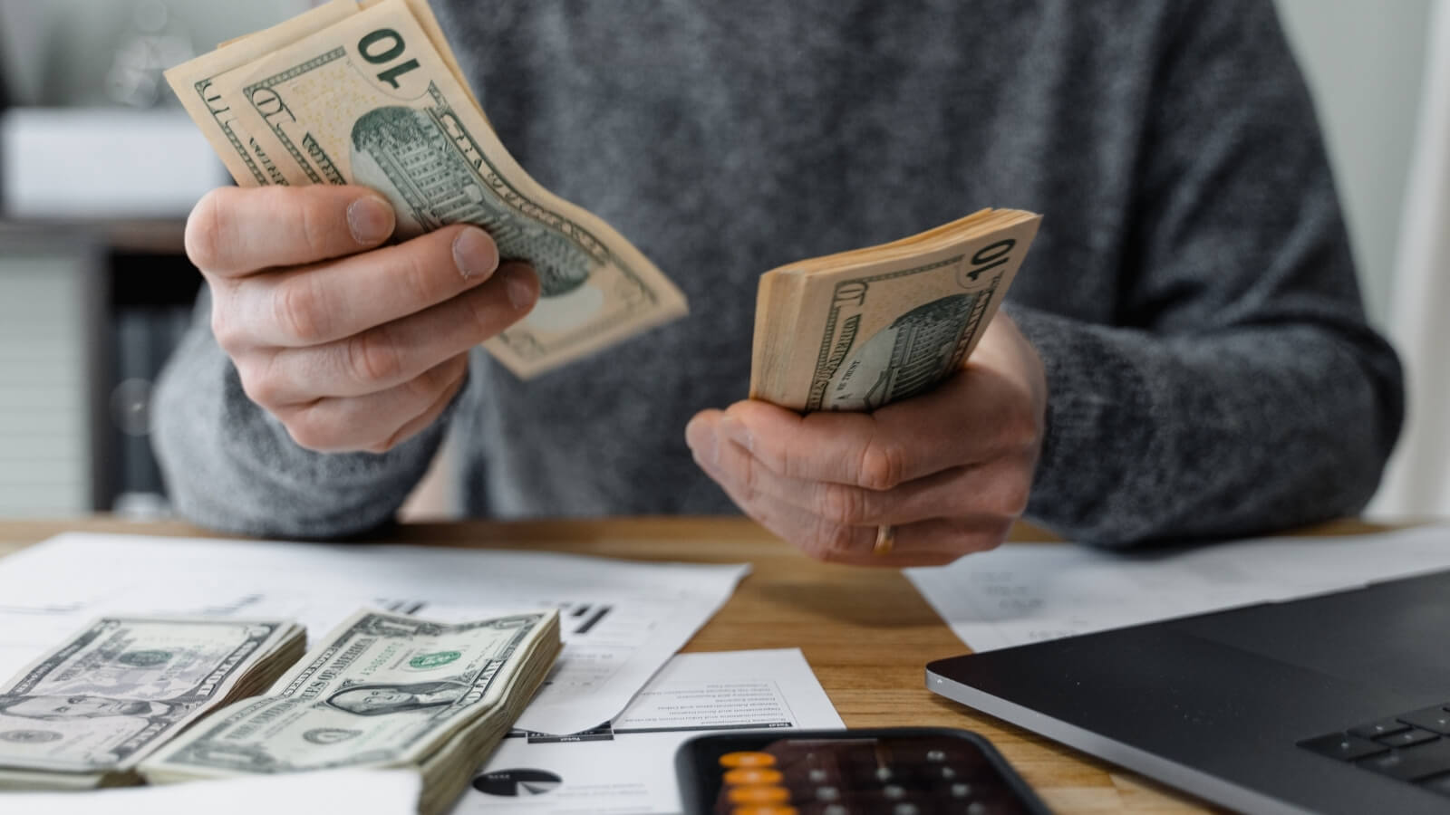 man counting money at desk